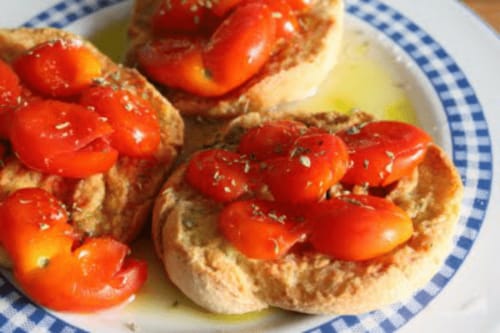 Bruschetta con pomodori freschi ed erbe aromatiche su piatto bianco a Panoramici Monolocali, Leuca