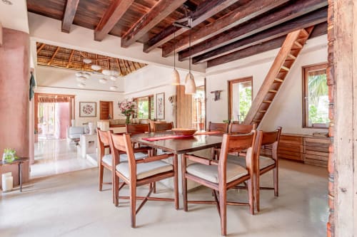 Spacious dining room in Cantarena House villa, Tulum with wooden beams, table for six, and sea views through multiple