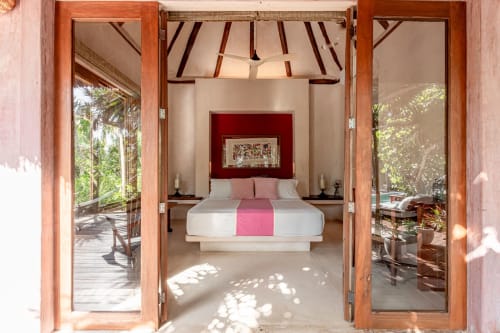 Tulum villa bedroom with canopy bed, open doors to tropical gardens, modern minimalist design