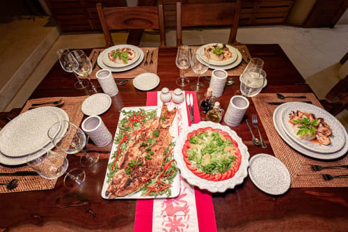 Elegant dining table at Cantarena House villa in Tulum set for four with plated seafood dishes and fresh salads