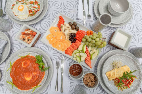 Elegant breakfast spread at Cantarena House villa in Tulum featuring fresh fruit, pastries, and gourmet dishes