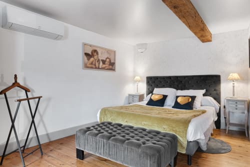 Chambre Muscadelle à Au Nid De La Madeleine : lit capitonné, poutres apparentes et vue sur la ville de Gaillac