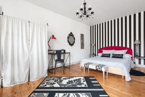 Chambre Braucol à Au Nid De La Madeleine à Gaillac avec tête de lit rouge, murs à rayures noires et décoration moderne