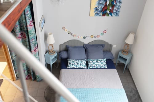 Chambre cosy au B&B Au Nid De La Madeleine à Gaillac avec lit tapissé bleu, tables de nuit jumelées et mur décoratif