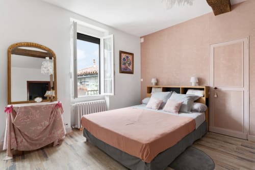 Chambre douillette à Au Nid De La Madeleine à Gaillac avec murs roses, lit en bois, coiffeuse avec miroir et vue sur le jardin