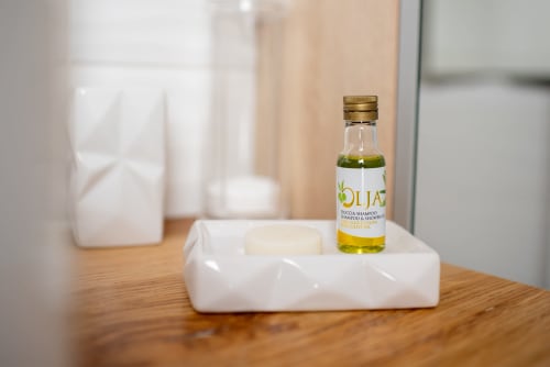 Amenities de bain Oliva sur plateau blanc dans la chambre d'hôtes Au Nid De La Madeleine, Gaillac France