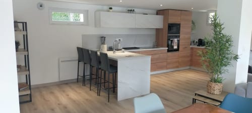 Cuisine et salle à manger modernes à la villa Gîte des Gônes à Feyzin, avec meubles blancs, accents bois et places assises pour trois