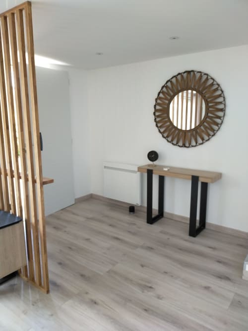 Espace de travail moderne à la Gîte des Gônes avec bureau en bois, miroir mural décoratif et lumière naturelle à Feyzin