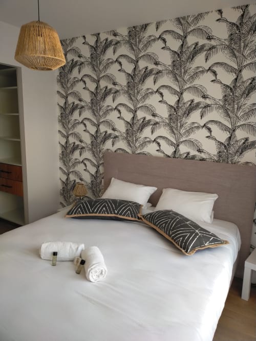 Chambre moderne à la villa Gîte des Gônes à Feyzin avec papier peint motifs palmettes, lit gris capitonné, linge blanc