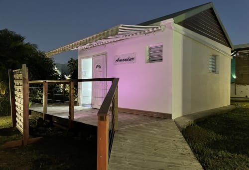 Bungalow rose avec terrasse en bois à la Kaz A Bibi guesthouse à Sainte-Rose, Guadeloupe, illuminé au crépuscule