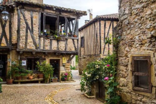 Cour médiévale de l'Au Nid De La Madeleine avec colombages et plantes fleuries à Gaillac