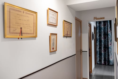 Couloir de la maison d'hôtes Au Nid De La Madeleine à Gaillac avec certificats encadrés et entrée de la chambre Mauzac