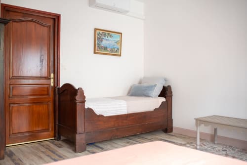Chambre avec lit en bois et mobilier rustique à Au Nid De La Madeleine, chambre d'hôtes à Gaillac, France