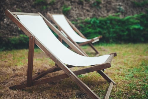 Chaises longues en bois avec coussins crème dans le jardin du cottage Bobochic d'ART DE VOYAGER, Étretat