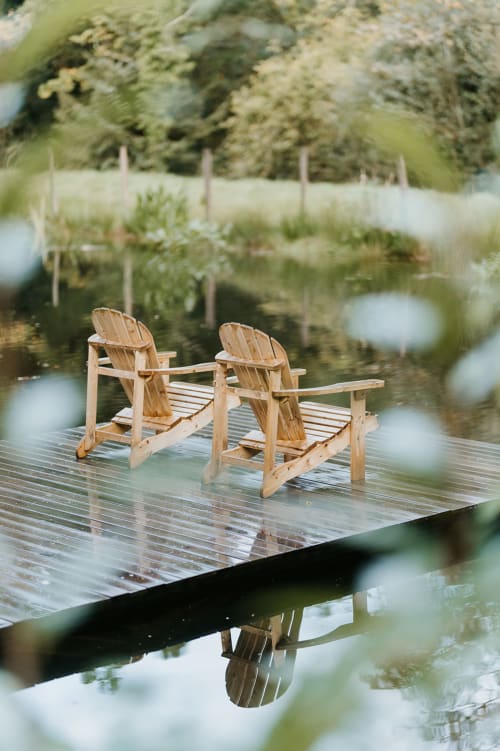 Deux chaises Adirondack en bois sur un ponton mouillé dominant un étang aux Gîtes du Bulz à Pleyber-Christ, Bretagne