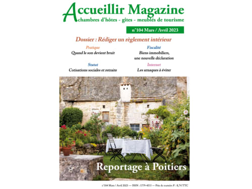 Charming garden courtyard at Poitiers B&B with table, chairs, flowering plants, and stone manor house backdrop