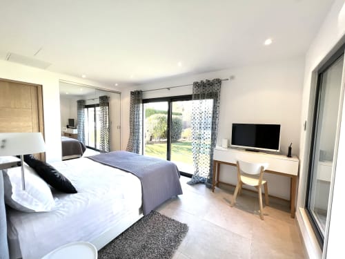Suite spacieuse avec lit queen, TV écran plat, bureau et vue sur le jardin à Villa La Cabane à Cap d'Antibes