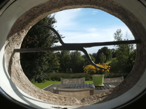L'oeil de boeuf, témoin du passé,  situé dans la salle commune  apporte une vue agréable sur le jardin
