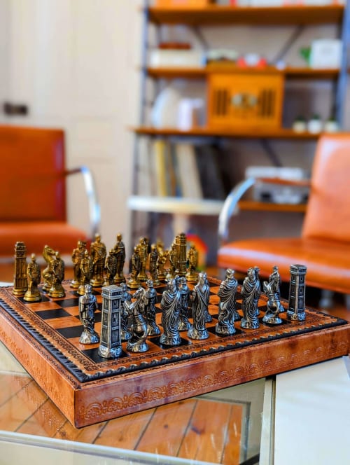 Jeu d'échecs raffiné avec pièces dorées et argentées sur plateau en bois à La Maison D'olivier B&B