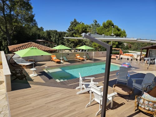 Terrazza piscina Villa Margherita con sdraio, ombrelloni verdi e pergolato affacciato su acque cristalline