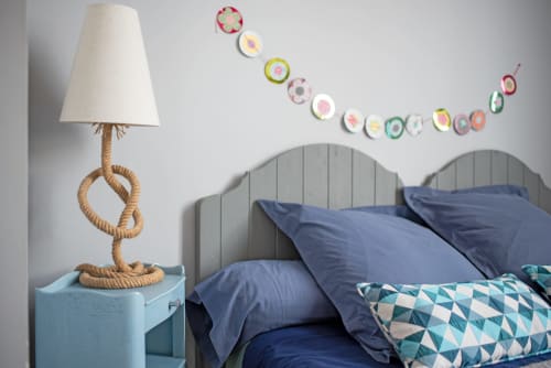 Chambre Au Nid De La Madeleine, Gaillac : lit à tête de lit bleu avec oreillers bleu marine, lampe en corde, décoration murale assiettes colorées et