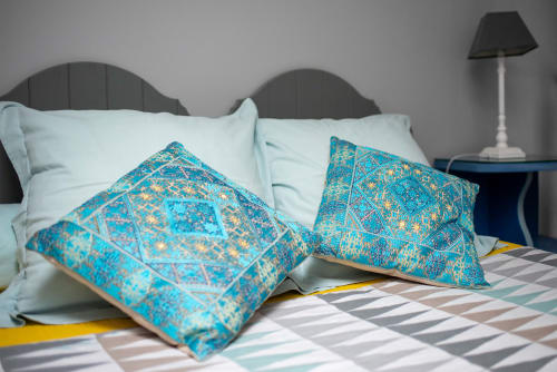 Coussins turquoise à motifs sur le lit de la chambre Mauzac à Au Nid De La Madeleine, Gaillac