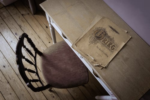 Chaise vintage avec coussin bordeaux et livre ancien à La Maison D'olivier, chambre d'hôtes française à Mesnard La