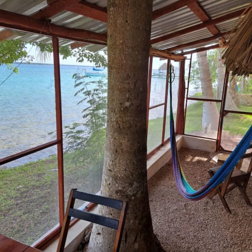 Porche cerrado con hamaca con vista al lago Bacalar en el hostal Cayuco Maya, México