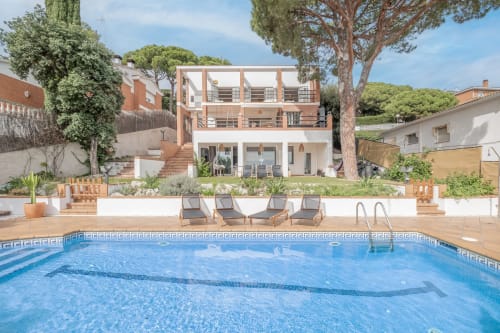 grande villa avec piscine, transats, parasols, espace détente au bord de la piscine,
