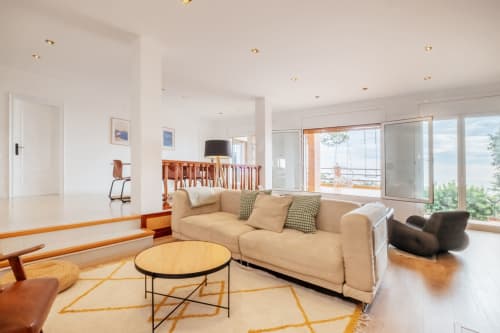 double salon avec TV cheminée, vue mer, 2 canapés, parquet, salle à manger, grande table