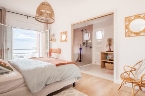 suite parentale avec salle de bain ouverte, ambiance bohème chic, chaleureux, vue mer, rotin