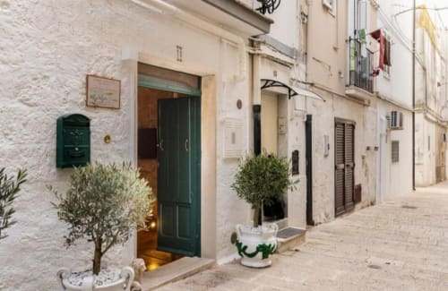 Charming whitewashed alley at CorteLirice Paradiso, Italian apartment with green door and potted plants