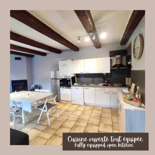 Cuisine ouverte entièrement équipée avec mobilier blanc et coin repas dans l'Appartement chez Lulu au gîte du château, Schirmeck