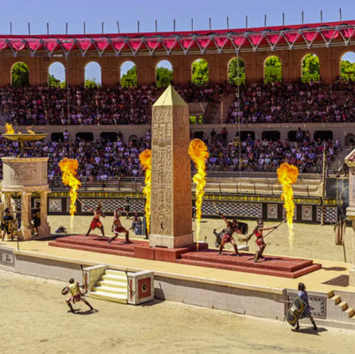 Arène d'amphithéâtre romain avec gladiateurs, foules, flammes dorées et obélisque égyptien
