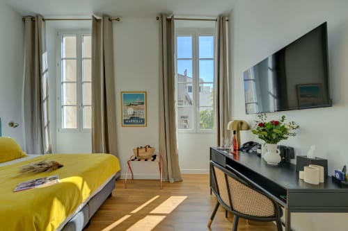 Camera Superiore luminosa del Boutique Hôtel Provencia a Marsiglia con biancheria gialla, scrivania, TV a schermo piatto e vista su