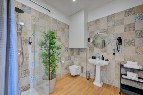 Bagno moderno al Boutique Hôtel Provencia con piastrelle decorate, doccia walk-in, lavabo su colonna e pianta di bambù in vaso