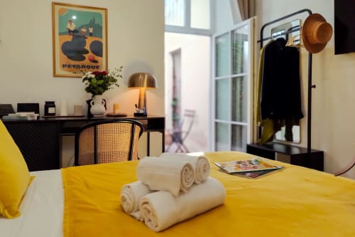 Luminosa camera standard del Boutique Hôtel Provencia a Marsiglia con biancheria gialla, asciugamani arrotolati, scrivania e arredamento vintage