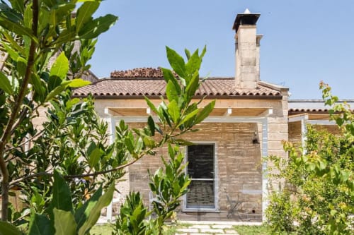 Masseria Vittoria, demeure en pierre traditionnelle avec toit de tuiles et cheminée, entourée de jardins luxuriants à Acaya, Vernole