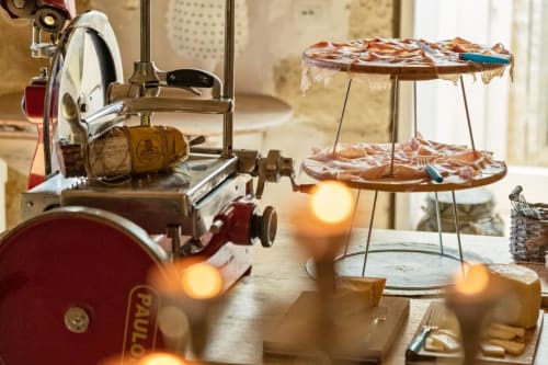 Affettatrice di carne d'epoca e stand a più livelli con prodotti da forno presso la Masseria Vittoria, Acaya