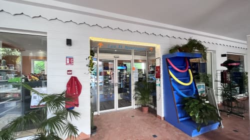 Caribluewave Appartements entrance in St-François, Guadeloupe with colorful watercraft display and tropical plants