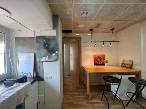Cocina moderna y comedor en los apartamentos Tessa en Matadepera con mesa de madera, barra y lámparas colgantes