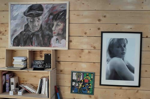 Mur de galerie artistique à la Villa République Normandie présentant portraits et photographies sur boiseries avec étagères