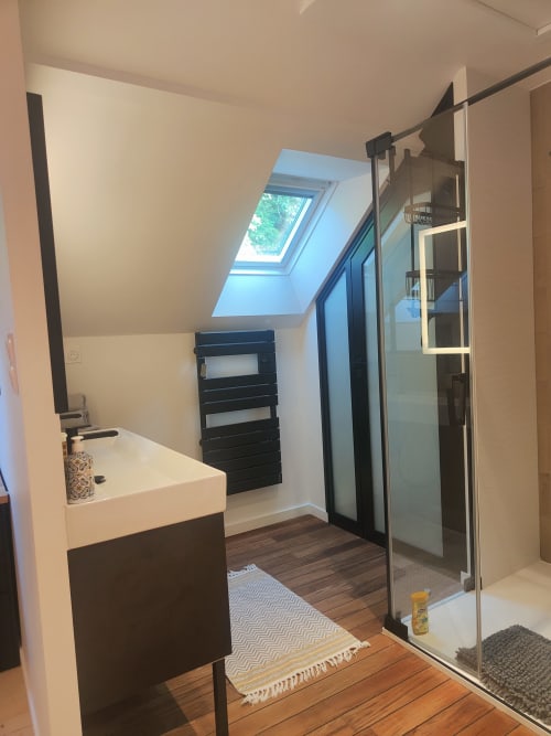 Salle de bain moderne du Studio Centre Audrey à La Conciergerie de Nathalie, Dinan, avec puits de lumière, lavabo, sèche-serviettes et