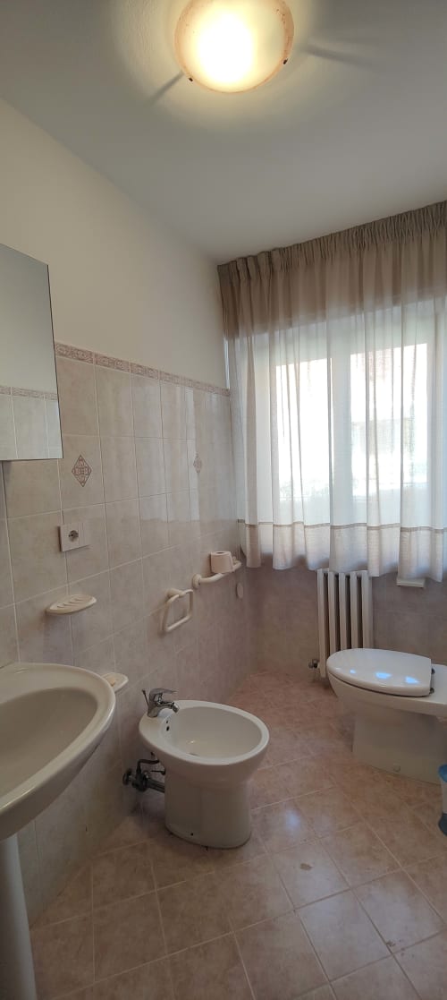Bagno accessibile nell'appartamento Villa Italia con toilette, bidet, lavabo e doccia attrezzata con barre di sostegno