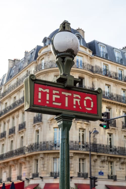 Élégant panneau de la ligne de métro parisienne avec lampadaire orné devant immeuble Haussmannien près de Maison 1850 Paris Porte Montmartre
