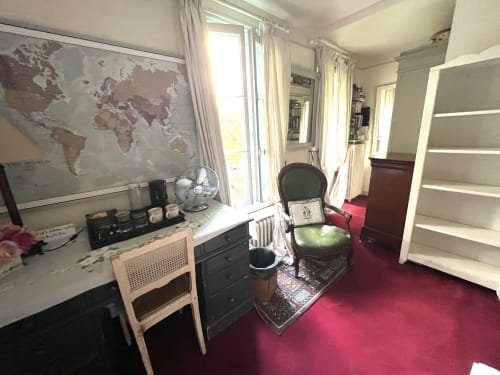 La chambre de Rita à la Maison 1850 Paris avec bureau, mappemonde, tapis bordeaux et portes donnant sur le jardin