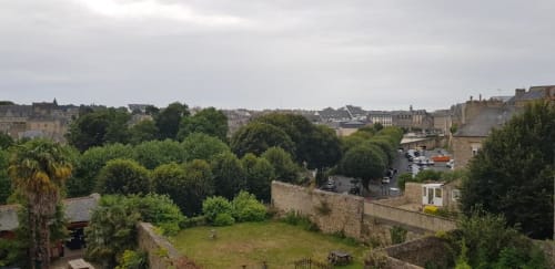 Vue pittoresque de la cité médiévale de Dinan avec ses remparts historiques, jardins verdoyants et architecture traditionnelle