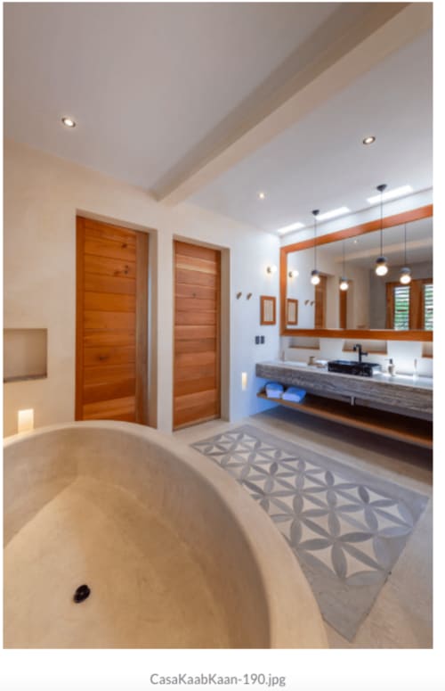 Baño de lujo moderno en villa Kaab Kaan House, Tulum, con bañera, doble tocador y puertas de madera