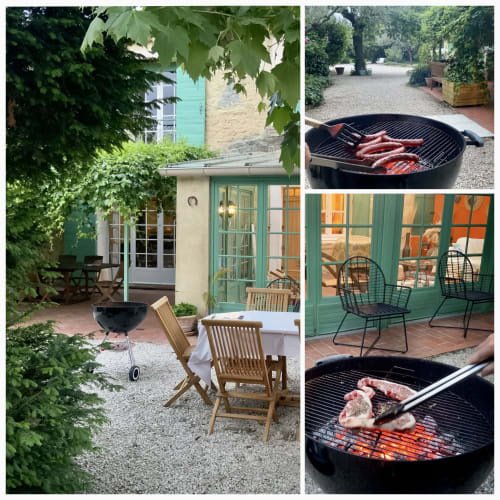  coin repas extérieur convivial au Mas des Olivades, une villa à Pernes-les-Fontaines, en Provence, France. L'espace comprend une table avec des chaises en bois et un barbecue.