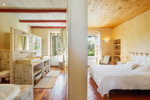 chambre suite lumineuse avec son grand lit et sa salle de bain équipée d'une baignoire et double vasque au mas des olivades à pernes les fontaines